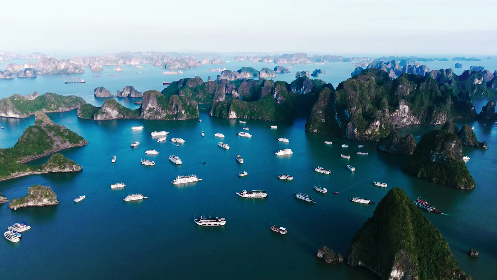 A cruise ship surrounded by the limestone islands of Halong Bay